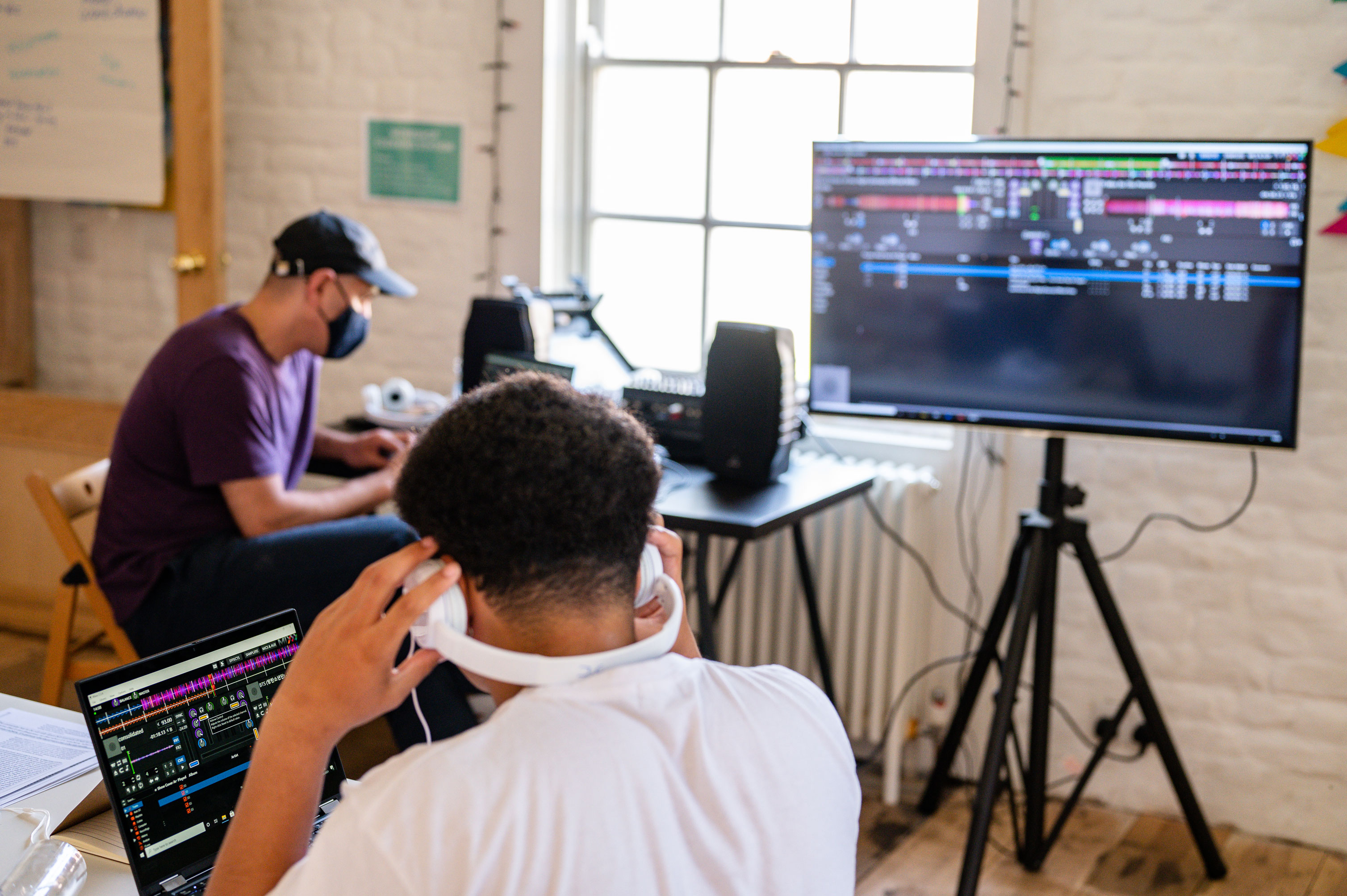 A participant wearing white headphones whilst using a laptop placed on a table