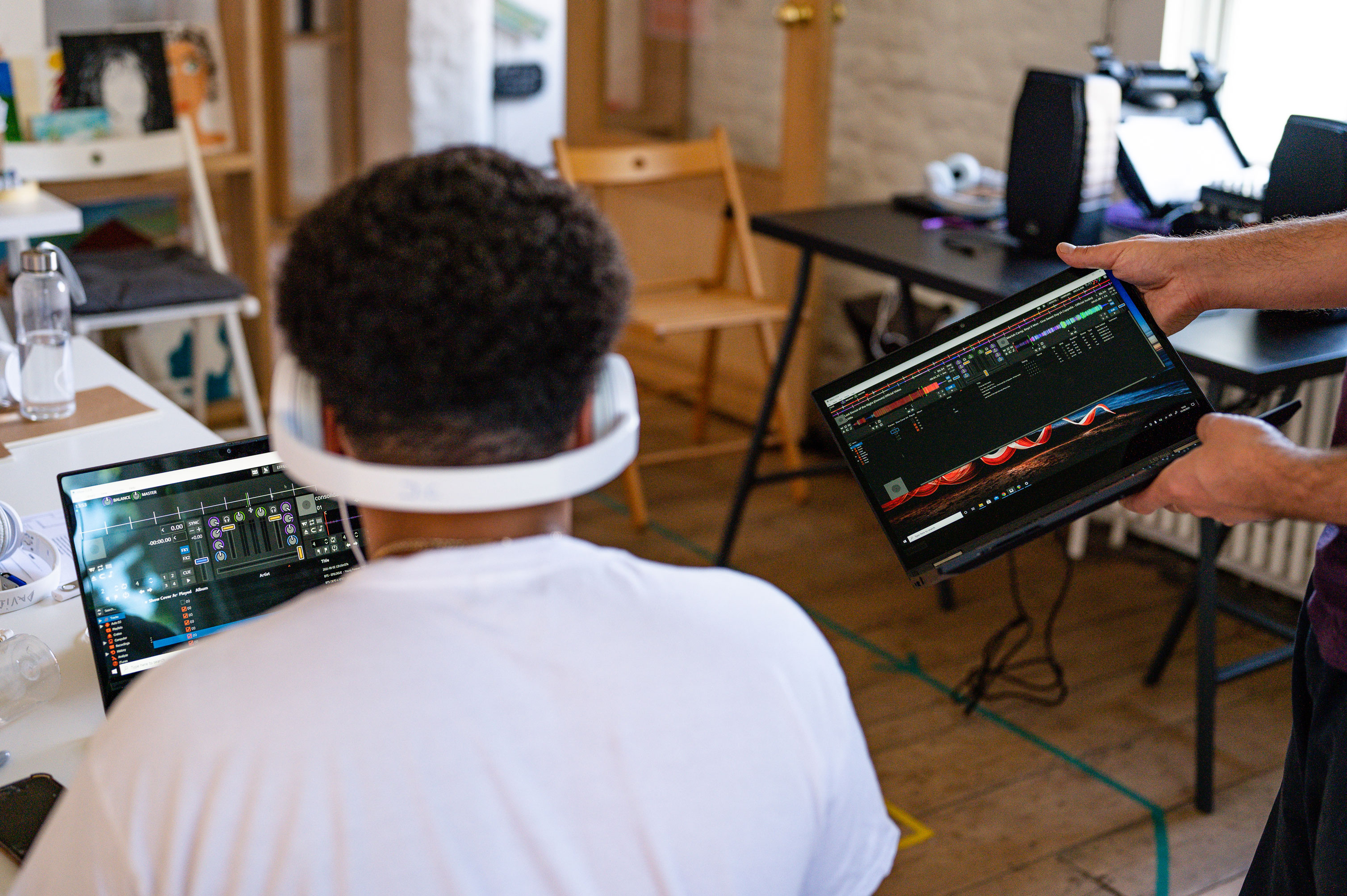 A participant wearing white headphones whilst using a laptop placed on a table