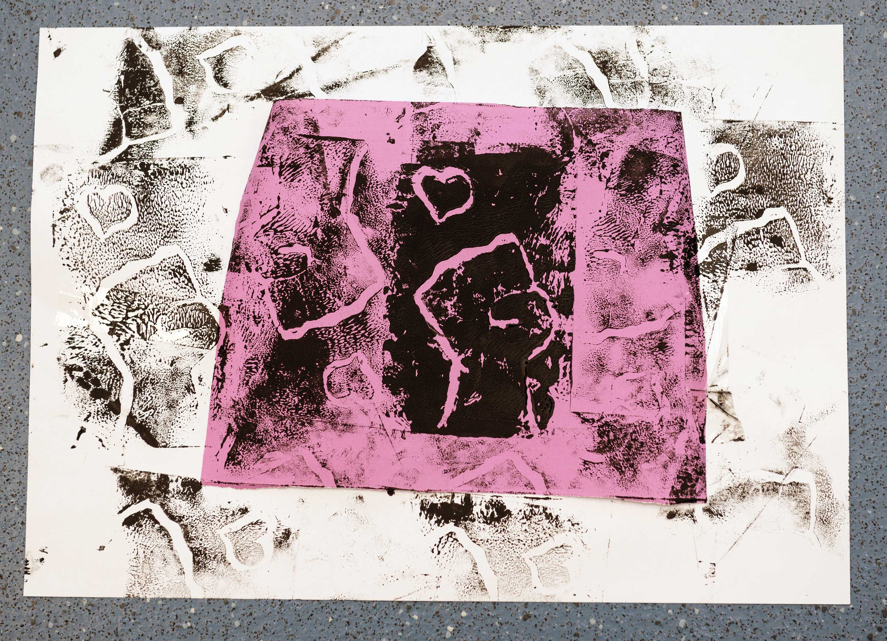A lino print of a clenched fist using black ink on a pink and white background