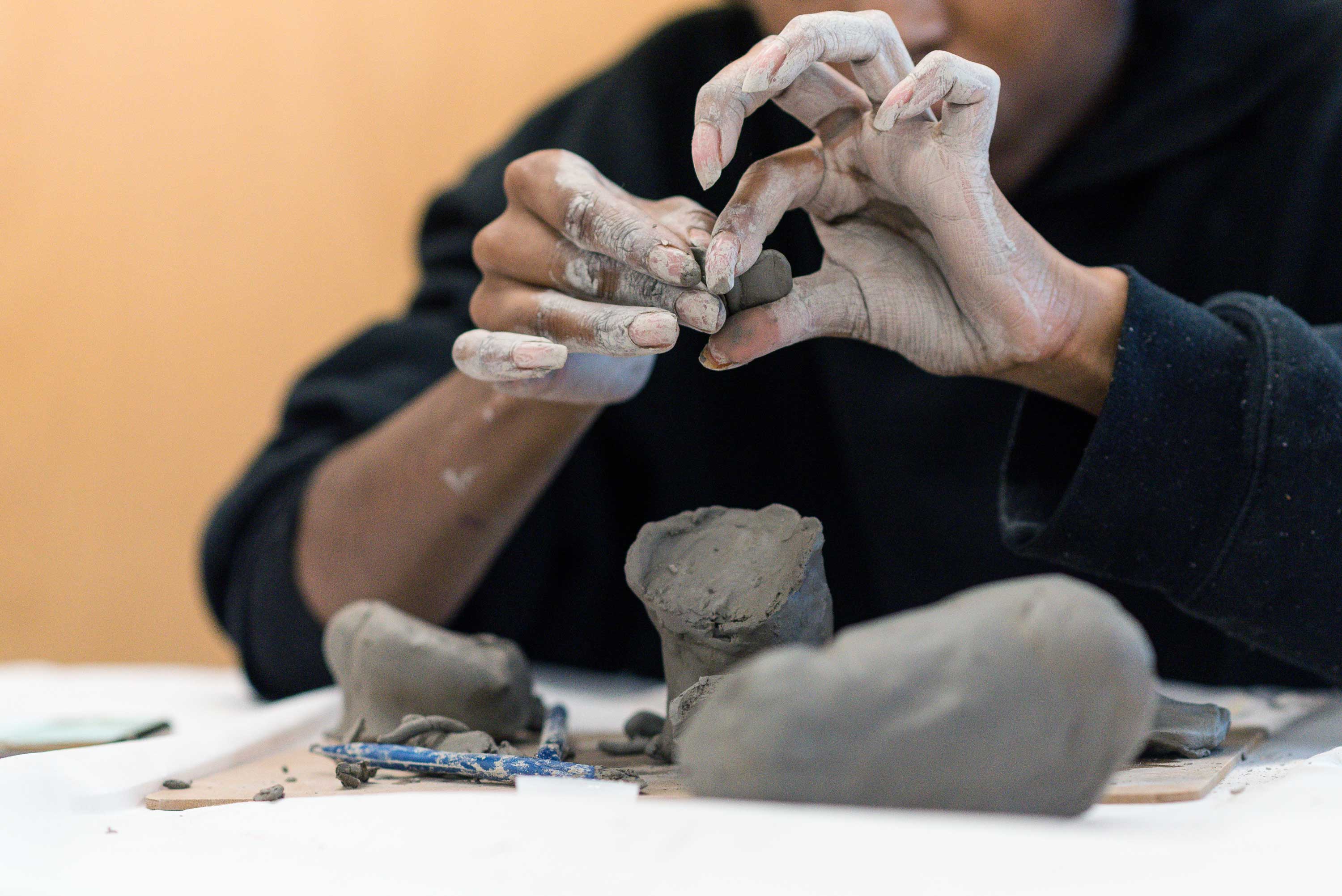 A close up of the participant using clay to create a sculpture