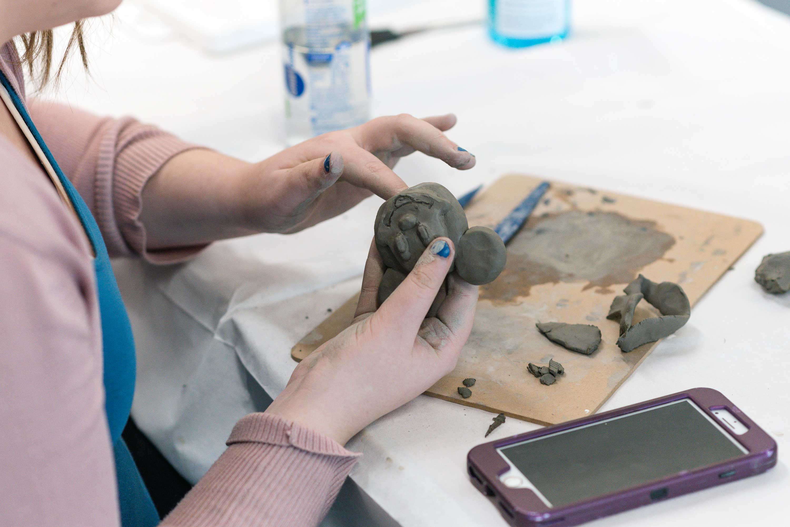 A close up of the participant using clay to create a sculpture