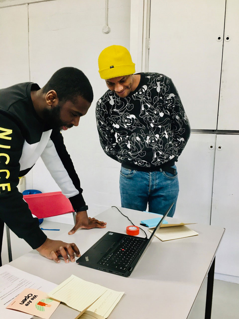 Two participants smiling and looking at a laptop placed on a work table