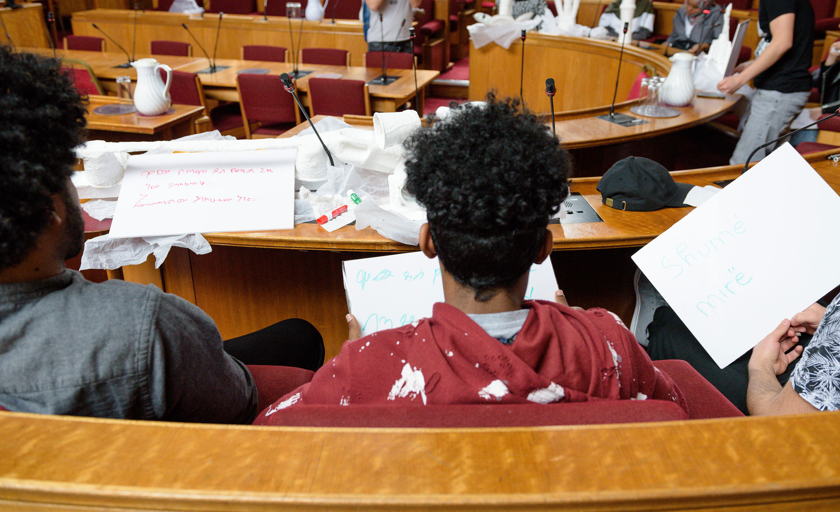 A group of young men sitting in the council chamber