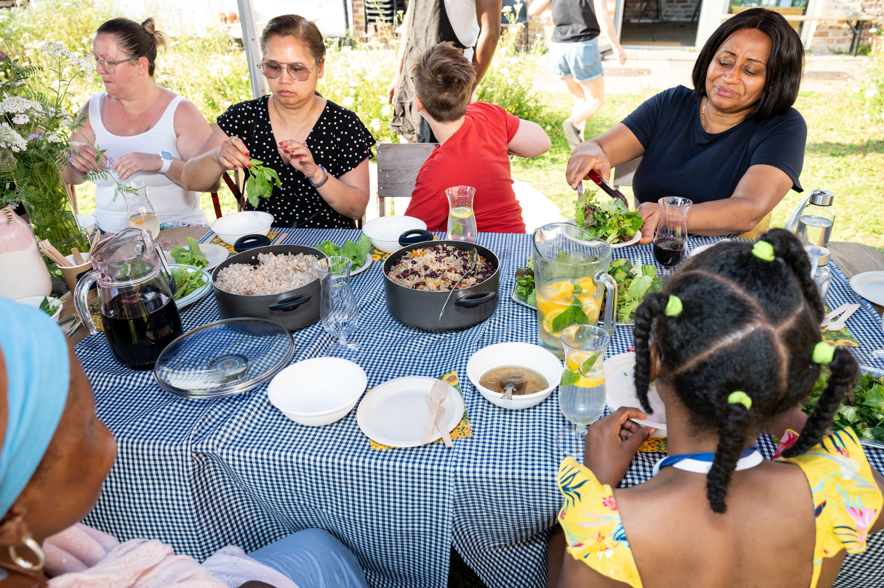 A group of adults and children sitting around a table eating lunch