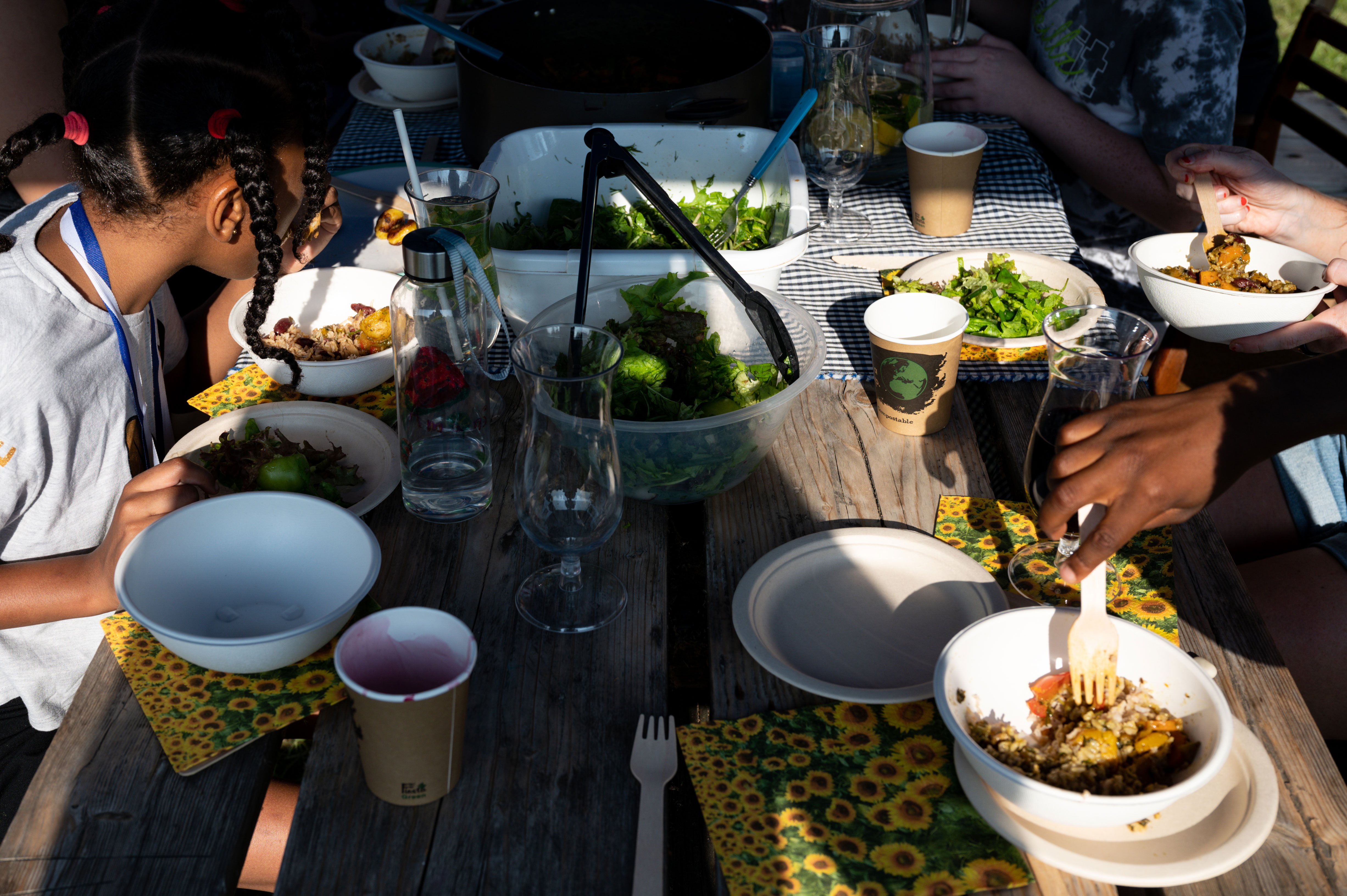 A group of adults and children sitting around a table eating lunch