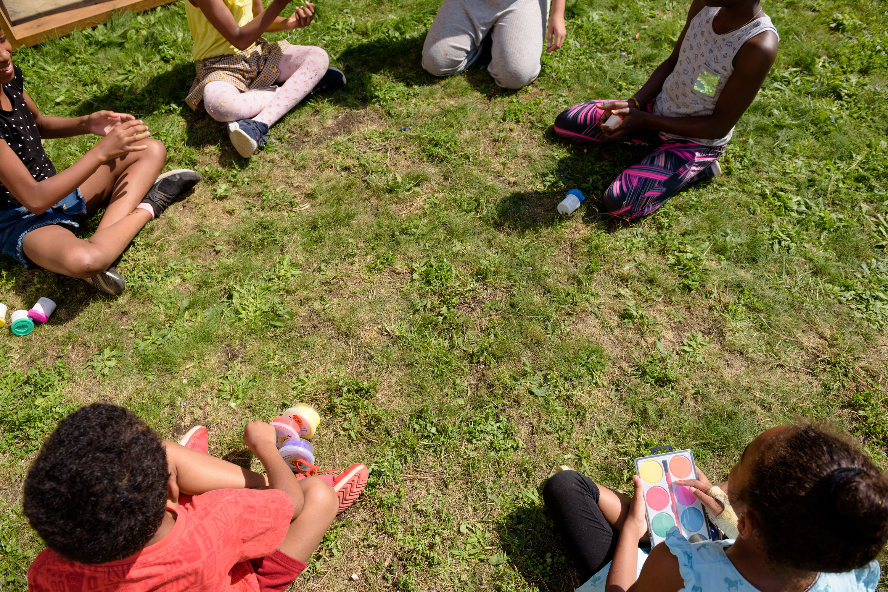 A group of young people sitting cross-legged on grass