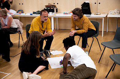A group of four people discussing and making notes on a large piece of paper