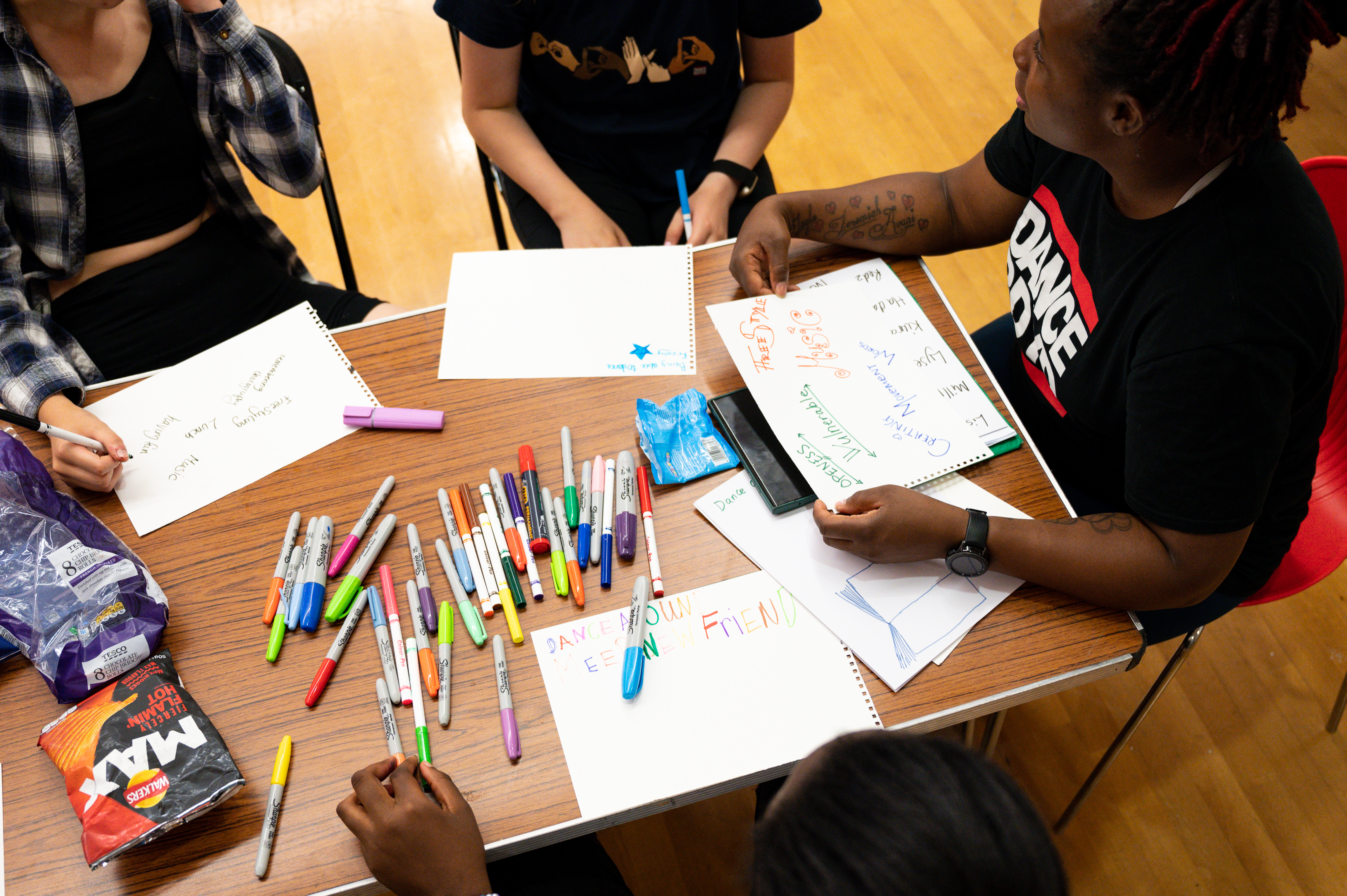 Young people drawing and eating snacks